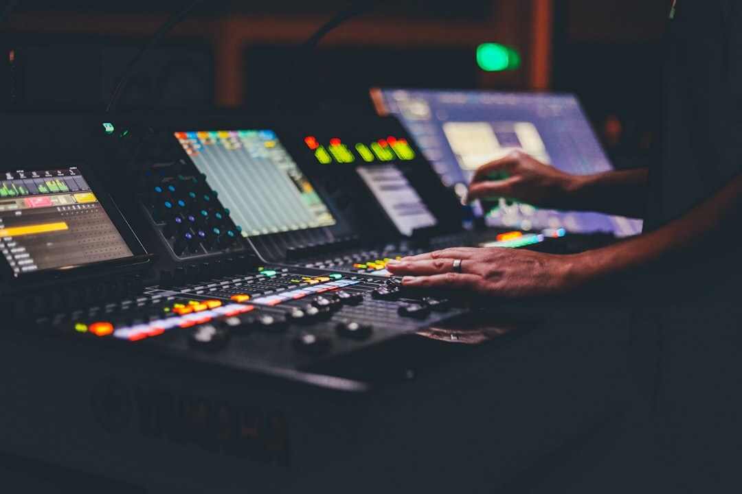 Close up of hands operating a video vision mixer switcher panel with illuminated buttons